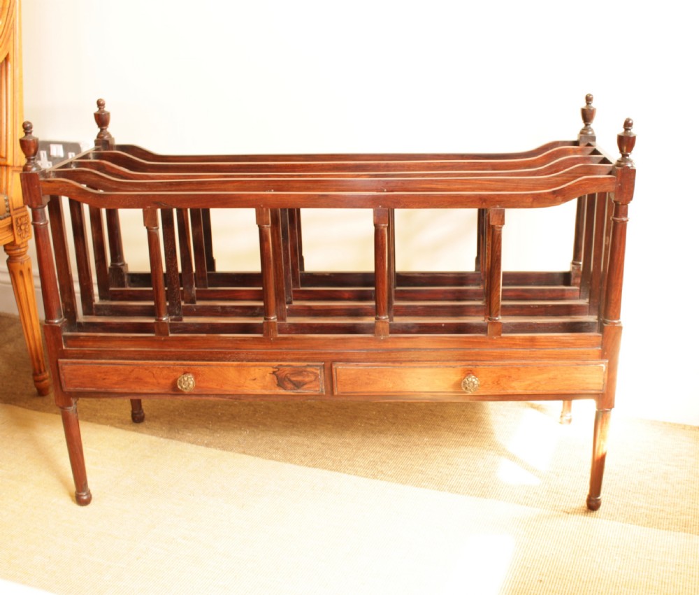 An antique Regency period dark rosewood double Canterbury featuring divided upper bays, turned corner posts with finials, two base drawers, and turned legs. View VIII