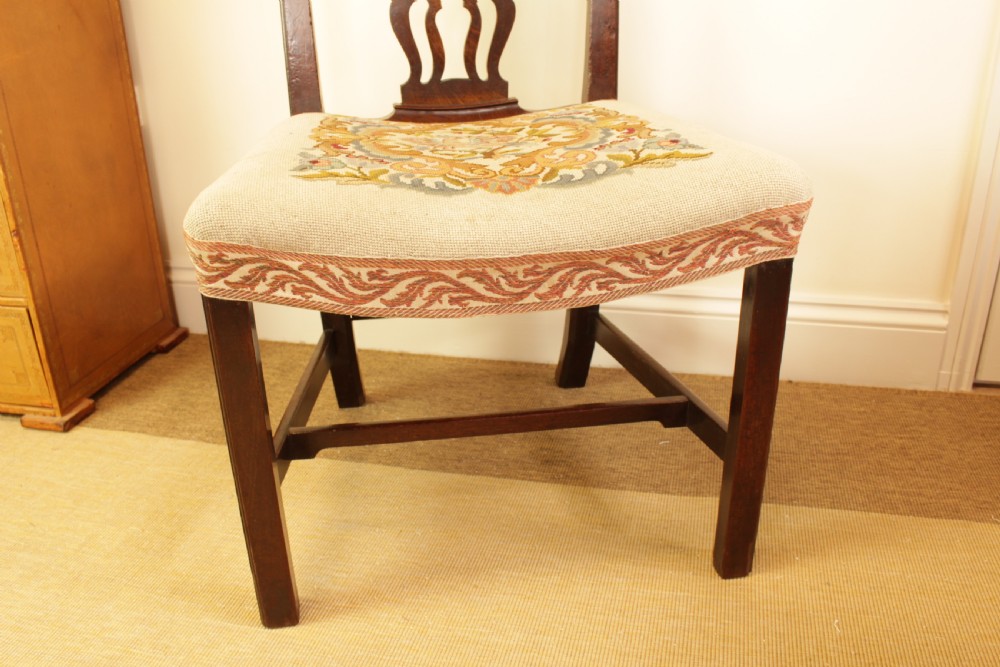 An antique mahogany side chair featuring a carved pierced splat back and a floral needlepoint upholstered seat. View IV