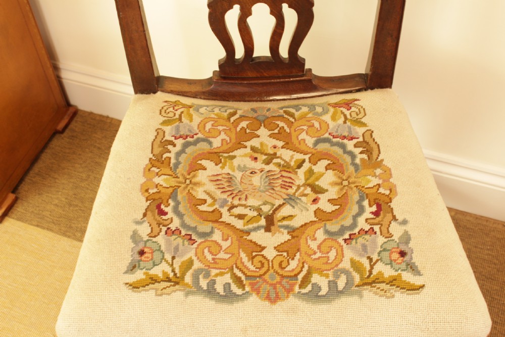 An antique mahogany side chair featuring a carved pierced splat back and a floral needlepoint upholstered seat. View VI