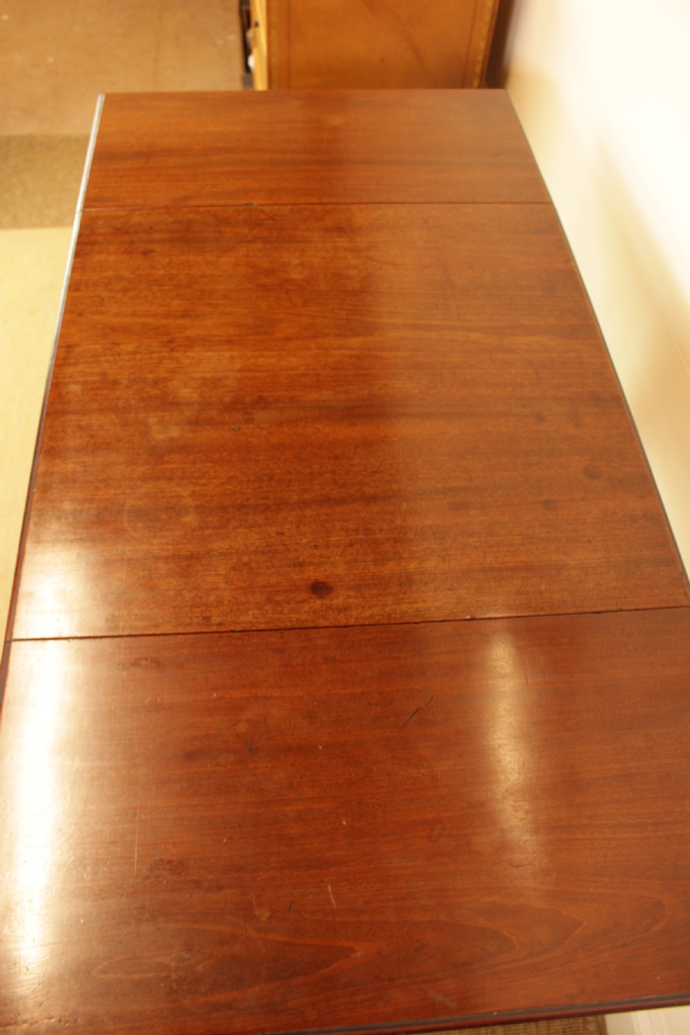 A Georgian mahogany drop-leaf side table featuring a single drawer with a brass handle, straight tapered legs, and brass castors. View VI