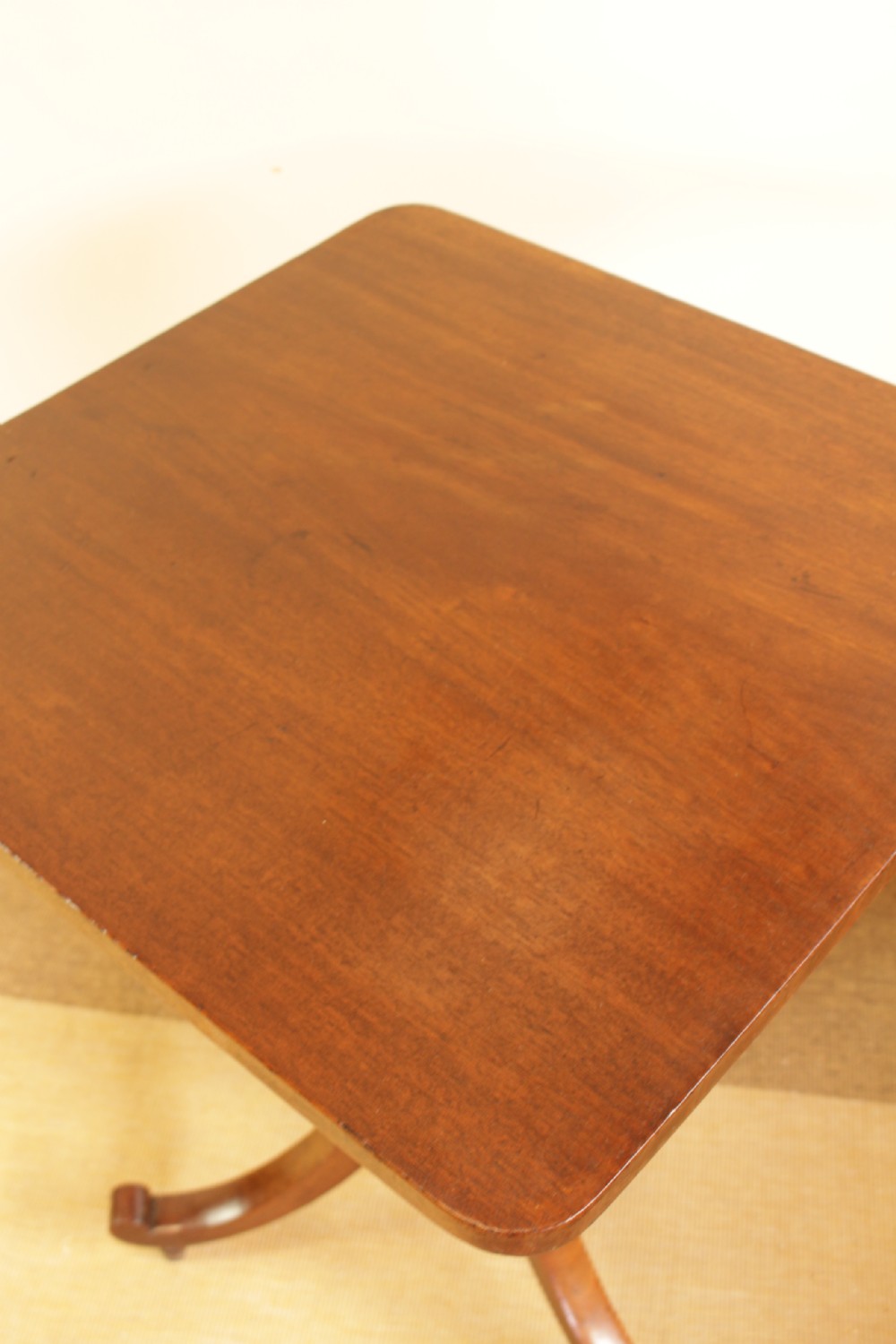 A mahogany tilt-top occasional table displayed with its rectangular top locked in a vertical position above a turned central column and tripod legs. View III