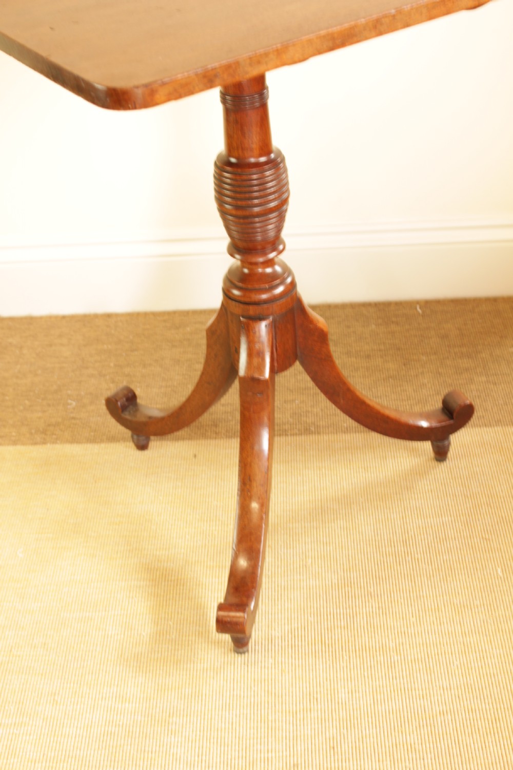A mahogany tilt-top occasional table displayed with its rectangular top locked in a vertical position above a turned central column and tripod legs. View IV