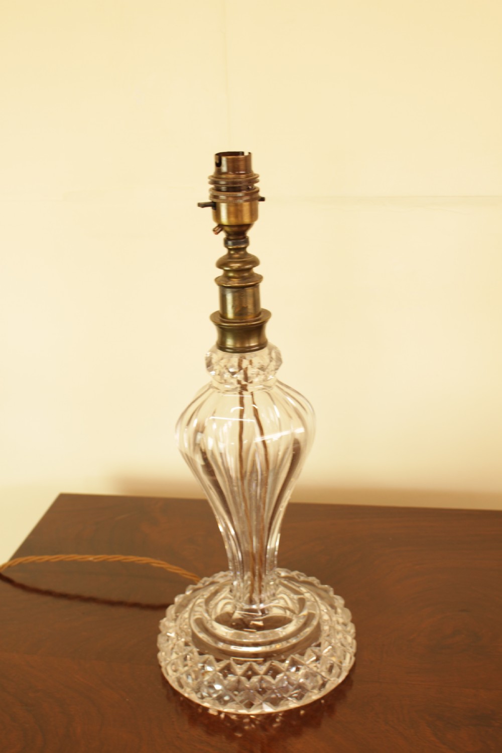 A cut crystal table lamp featuring a baluster-shaped glass base and a cream pleated fabric conical lampshade. View III