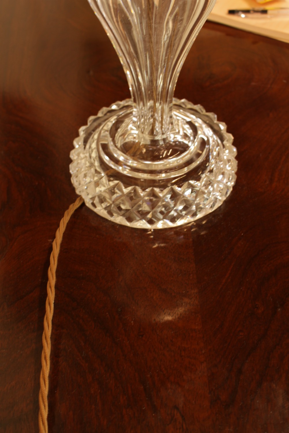 A cut crystal table lamp featuring a baluster-shaped glass base and a cream pleated fabric conical lampshade. View IV