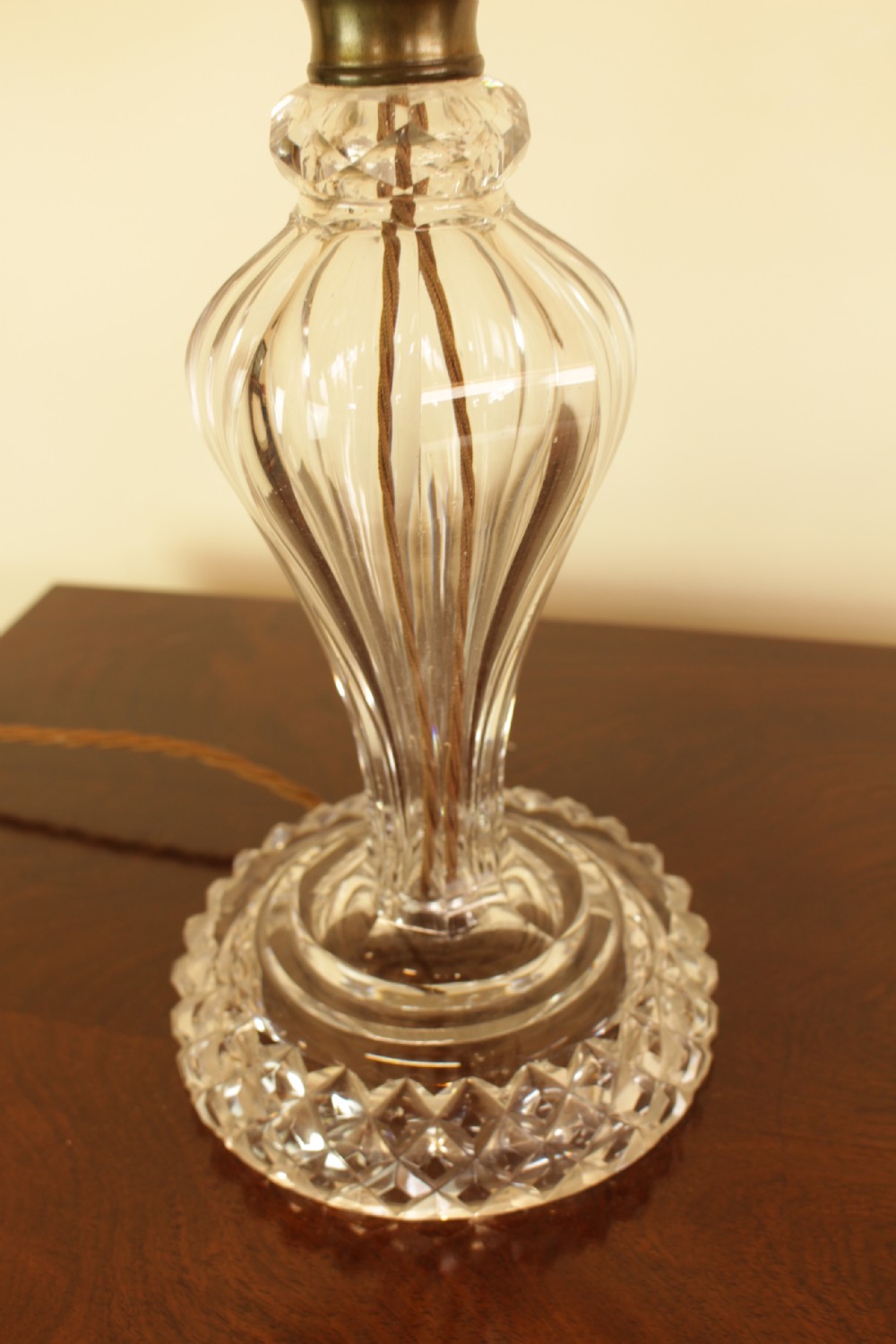 A cut crystal table lamp featuring a baluster-shaped glass base and a cream pleated fabric conical lampshade. View VI