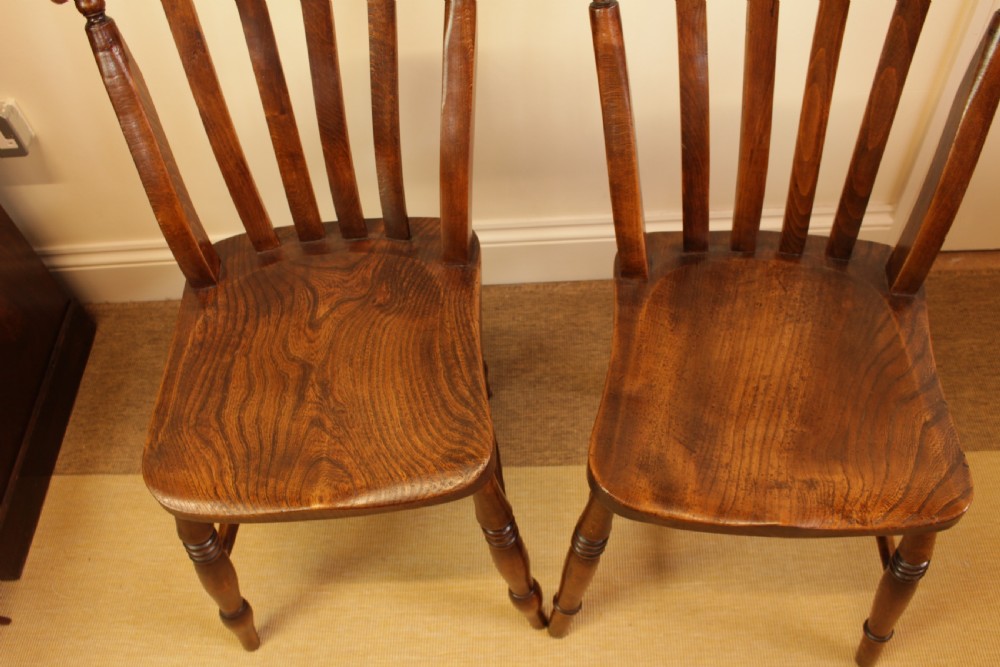 Set of four dark-stained wooden kitchen chairs featuring shaped elm seats, turned legs, and backrest spindles with curved top crest rails. View VII