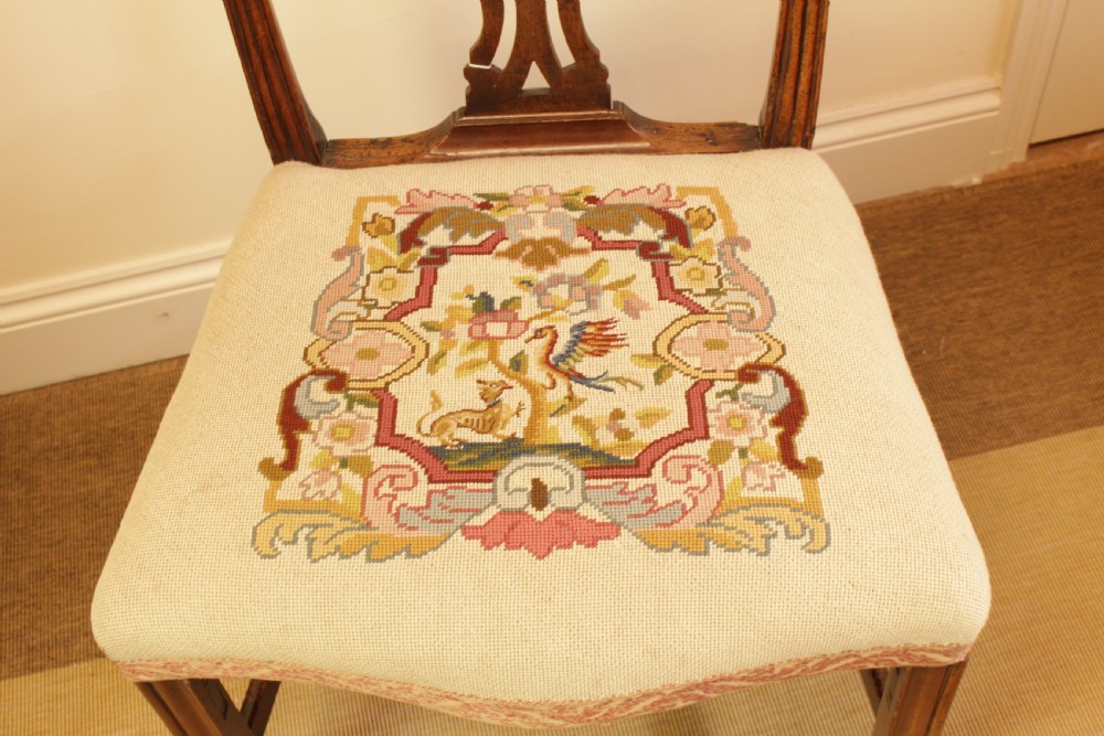An 18th-century Chippendale-style carved mahogany side chair featuring a pierced back splat and a cream needlepoint tapestry seat. View X