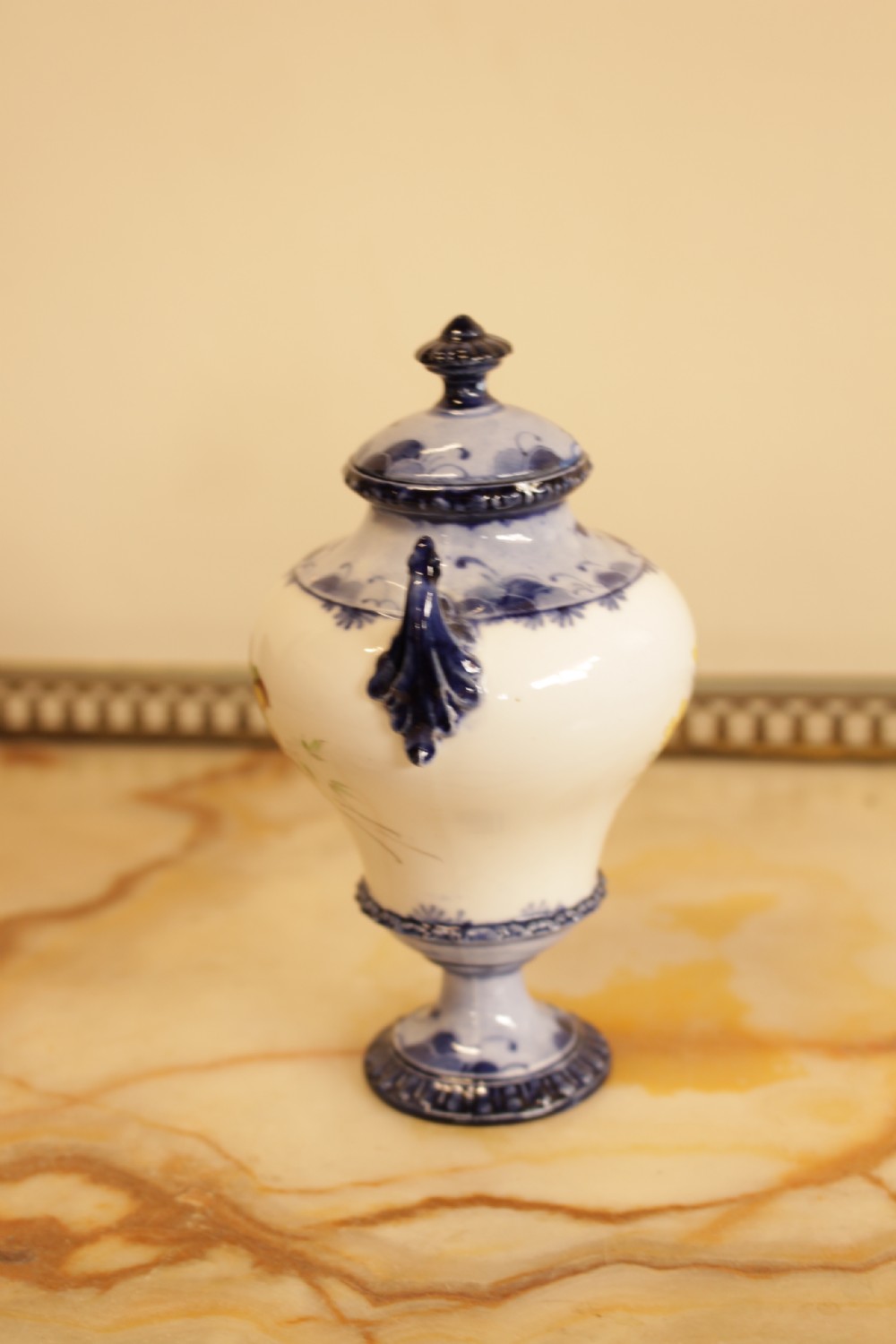 An antique porcelain lidded urn featuring hand-painted floral motifs, cobalt blue handles, and a pedestal base. View IV