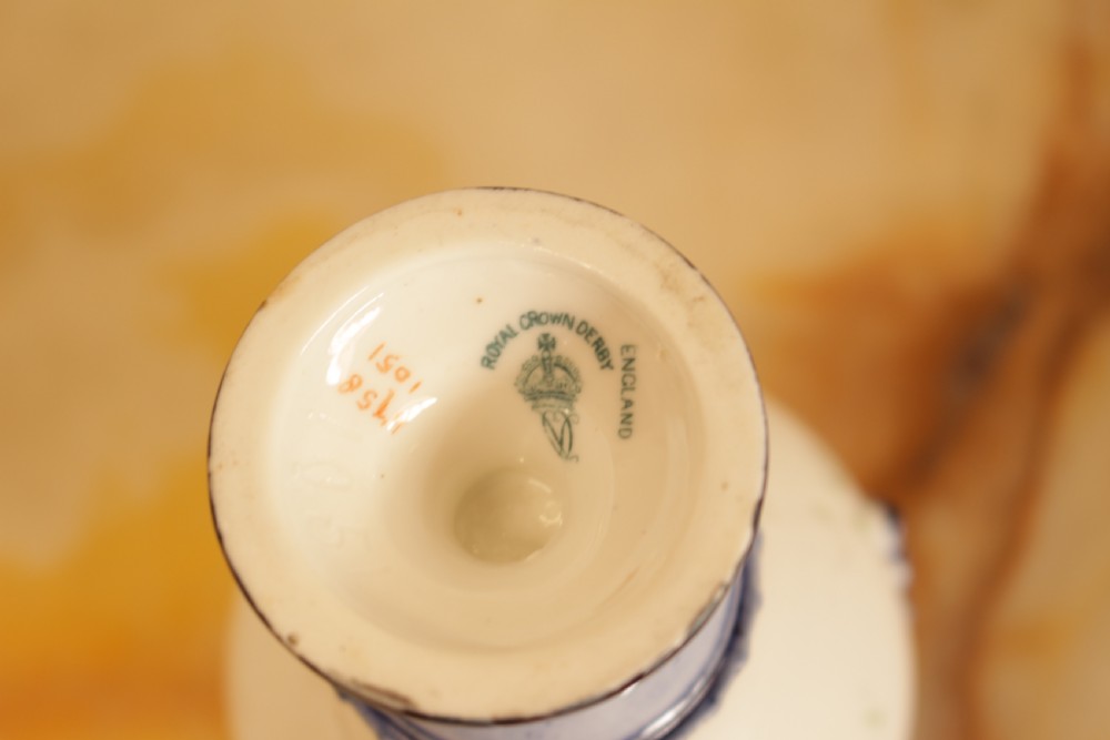 An antique porcelain lidded urn featuring hand-painted floral motifs, cobalt blue handles, and a pedestal base. View X