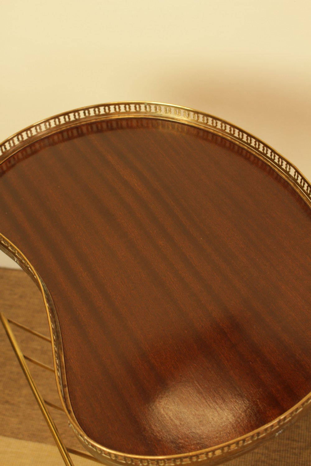 A brass occasional side table featuring a kidney-shaped top surface with a pierced gallery rail, faux bamboo tripod legs, and an integrated wire magazine rack. View III