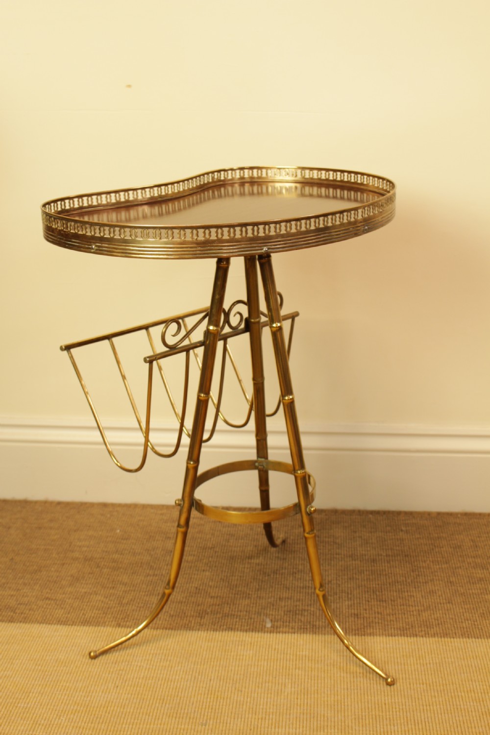 A brass occasional side table featuring a kidney-shaped top surface with a pierced gallery rail, faux bamboo tripod legs, and an integrated wire magazine rack. View IV