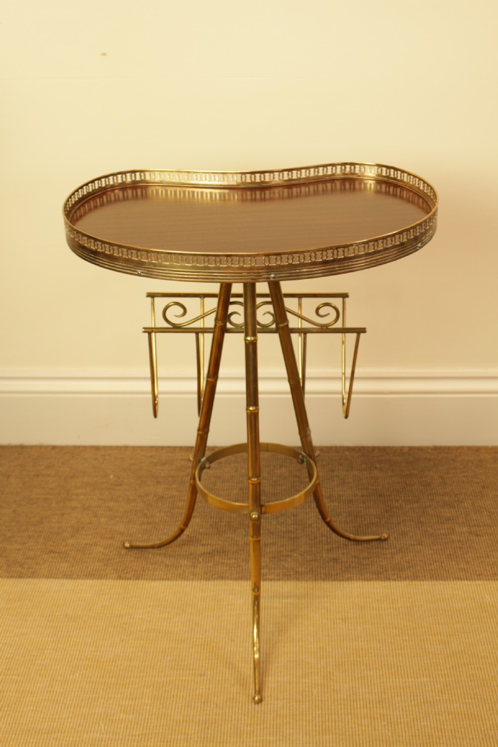 A brass occasional side table featuring a kidney-shaped top surface with a pierced gallery rail, faux bamboo tripod legs, and an integrated wire magazine rack. View V