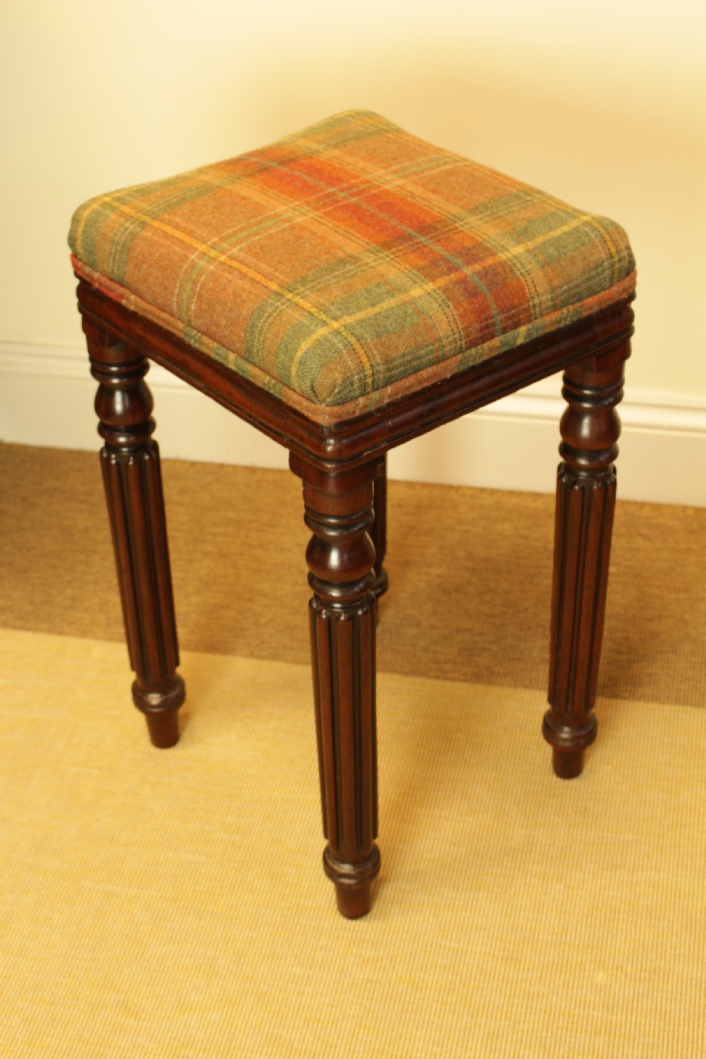 A 19th-century mahogany stool featuring turned reeded legs and a square tartan wool upholstered seat. View II