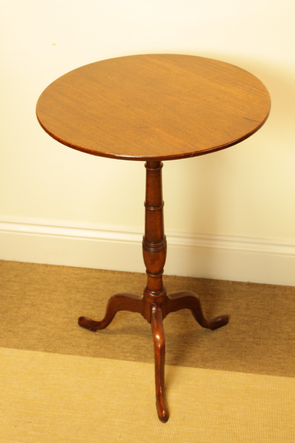 A George III period circular mahogany tilt-top table with a turned central column and tripod cabriole legs. View II