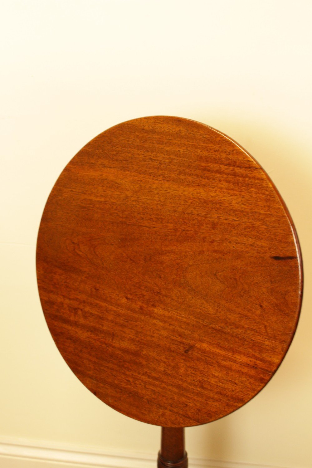 A George III period circular mahogany tilt-top table with a turned central column and tripod cabriole legs. View III