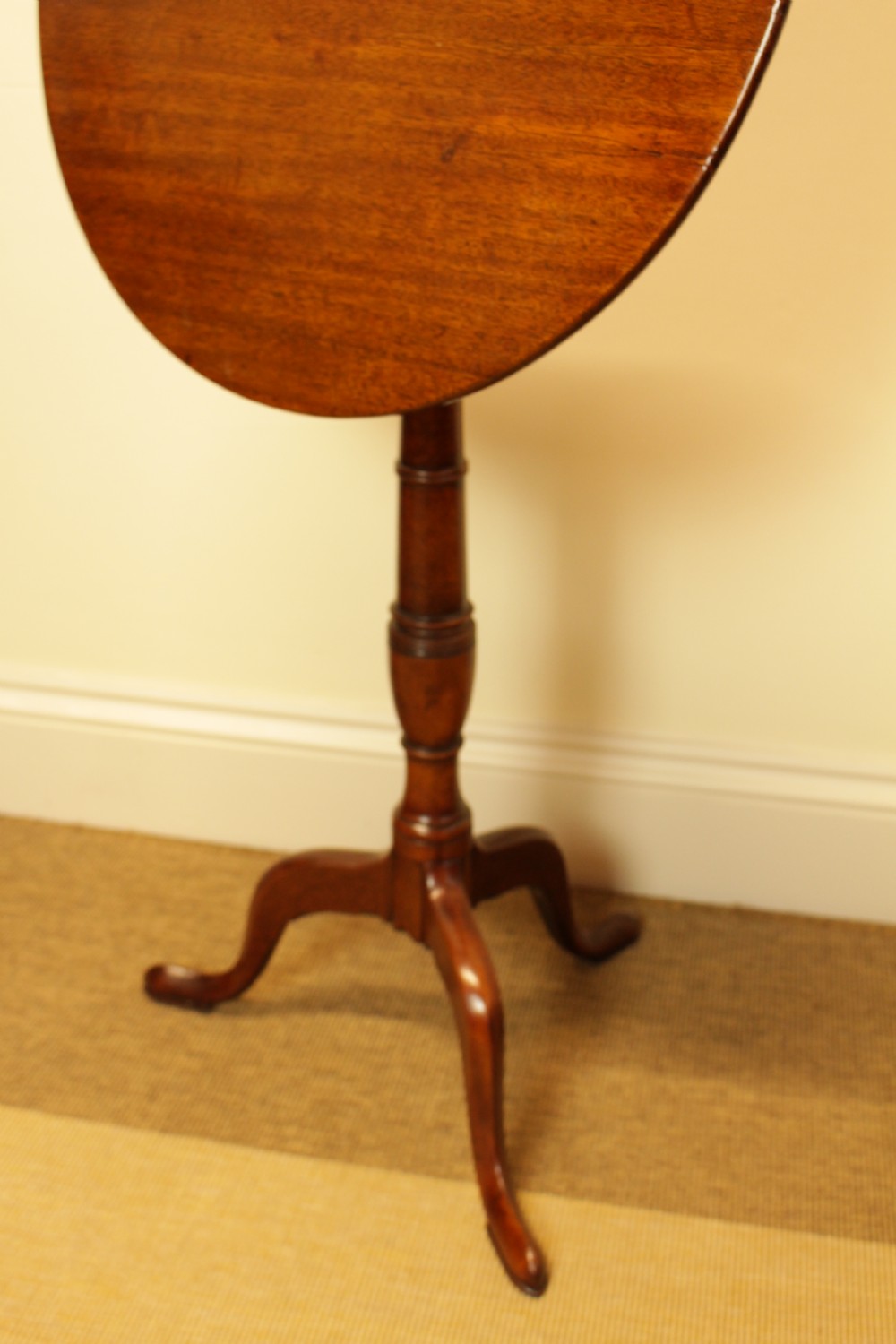 A George III period circular mahogany tilt-top table with a turned central column and tripod cabriole legs. View VI
