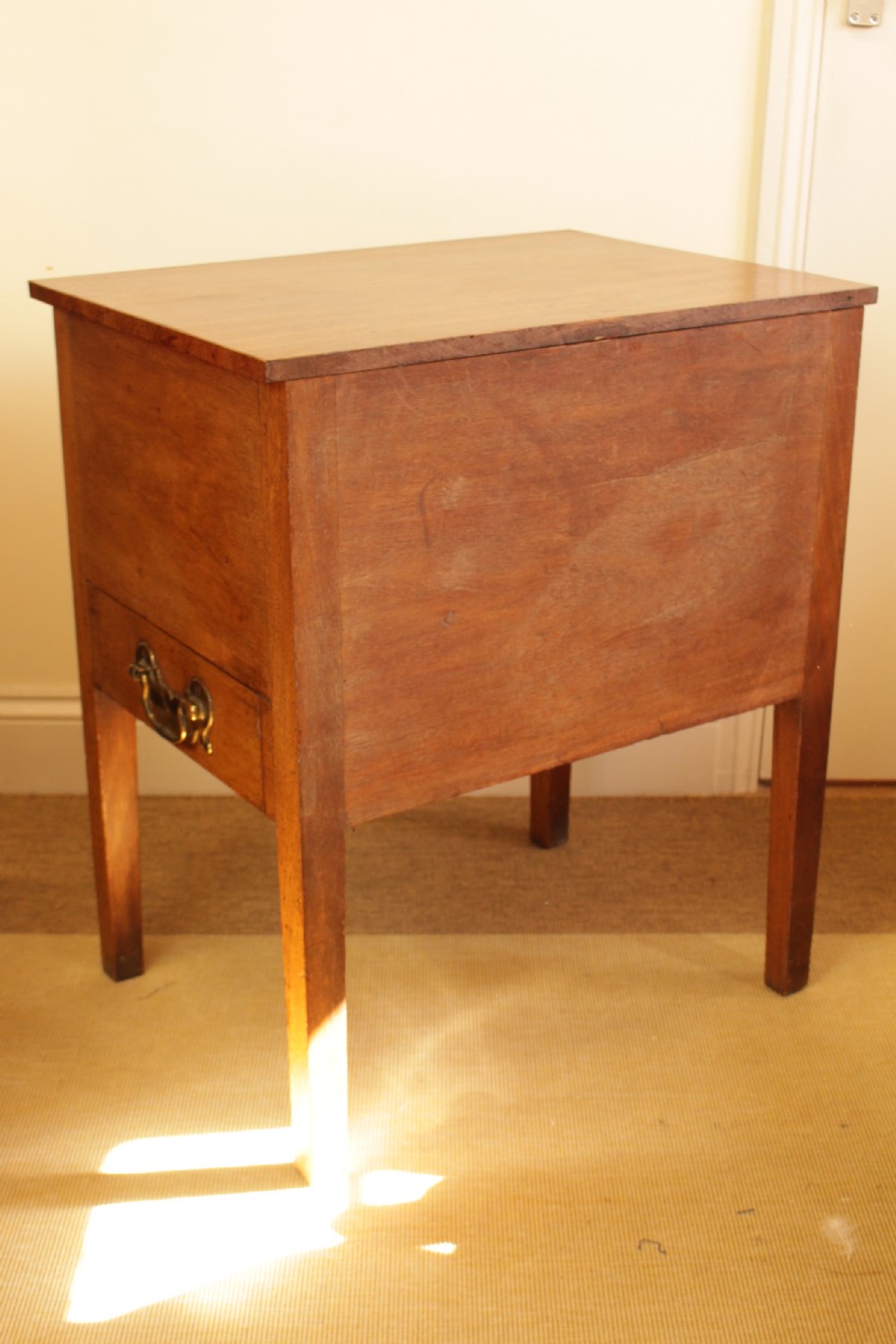 A Georgian mahogany cupboard featuring two panelled doors above a single drawer with brass swan-neck handles, supported on four straight square legs. View IV