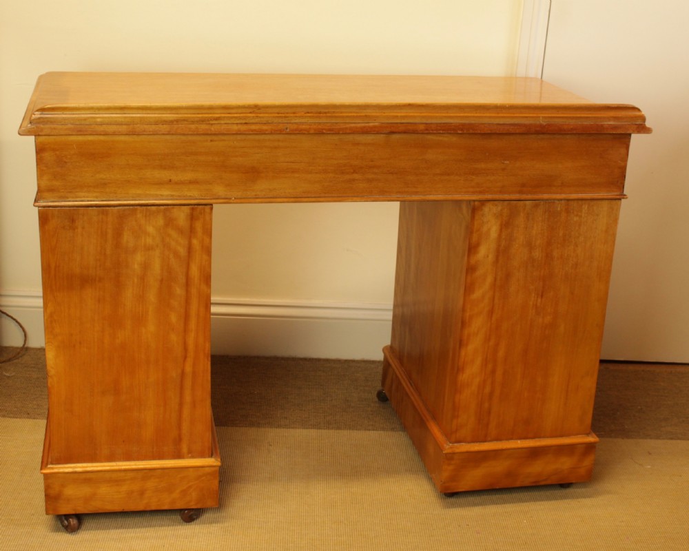 A late Victorian satin birch pedestal desk featuring nine drawers with turned handles, a low gallery back rail, and prominent golden wavy wood grain. View VIII