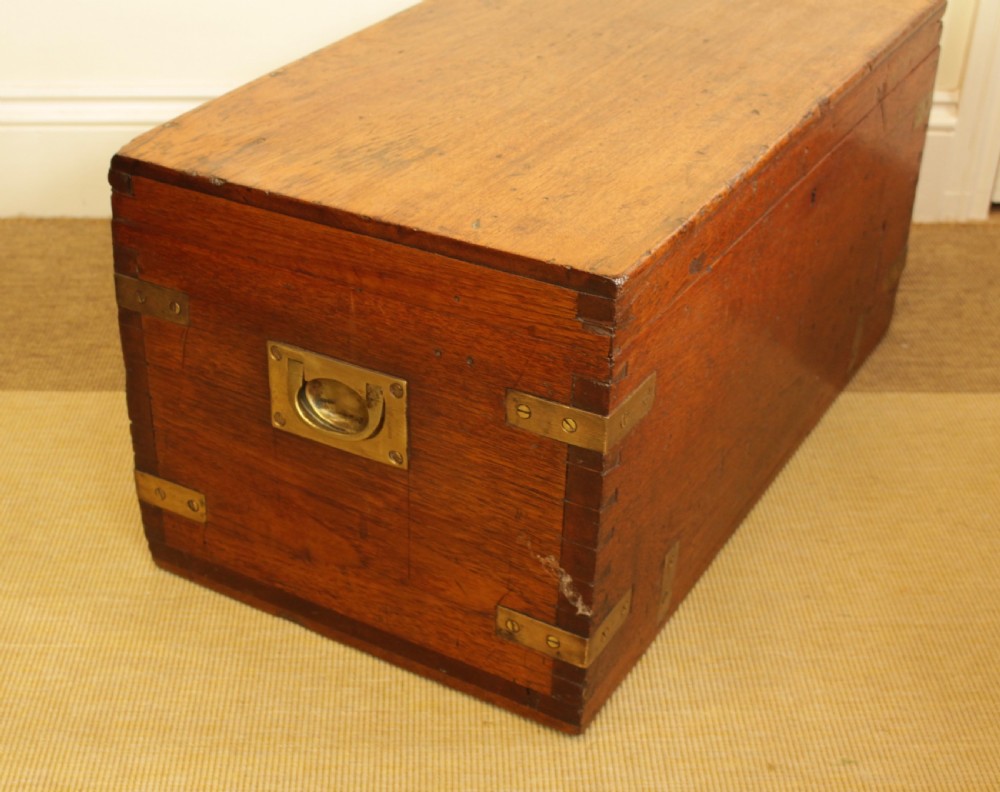 A rectangular warm brown camphorwood storage trunk featuring brass corner straps, hand-cut dovetail joints, and a central keyhole. View IV