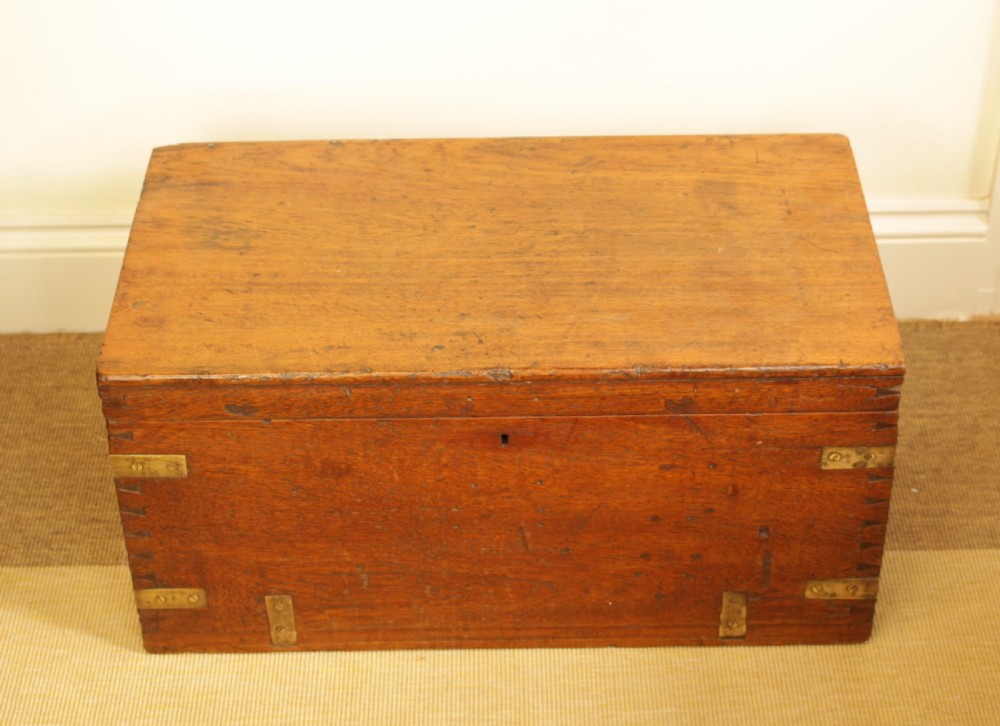 A rectangular warm brown camphorwood storage trunk featuring brass corner straps, hand-cut dovetail joints, and a central keyhole. View VII
