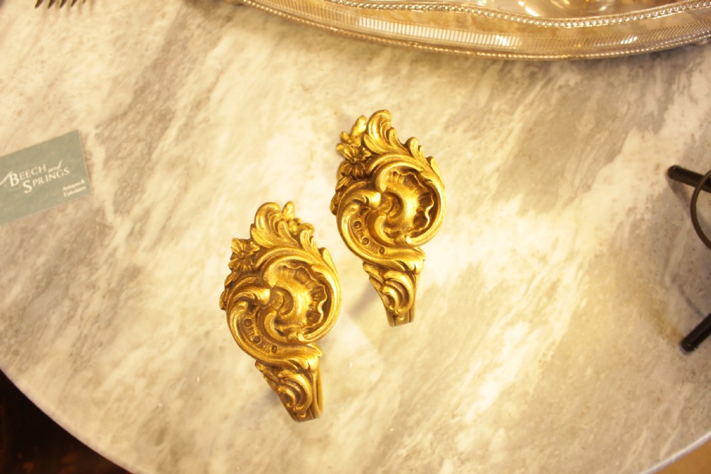 A pair of French Rococo gilt bronze curtain tiebacks featuring sculpted acanthus leaves and scrolling motifs. View II