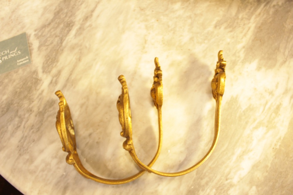 A pair of French Rococo gilt bronze curtain tiebacks featuring sculpted acanthus leaves and scrolling motifs. View III