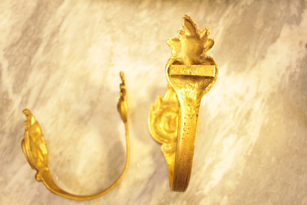 A pair of French Rococo gilt bronze curtain tiebacks featuring sculpted acanthus leaves and scrolling motifs. View IV