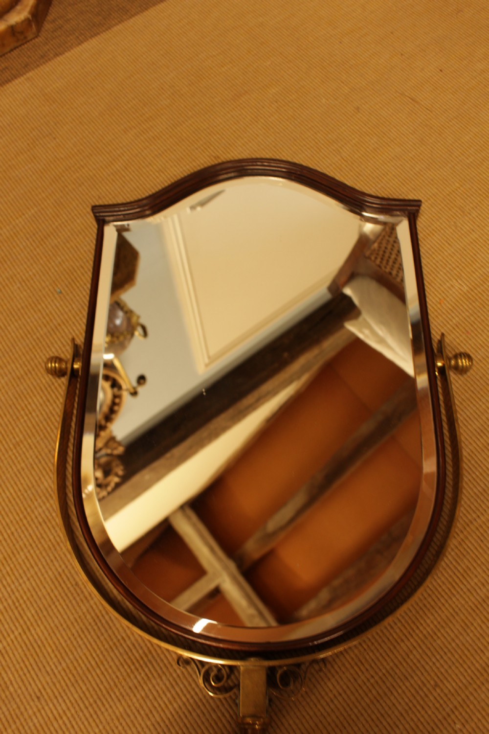A shield-shaped mahogany framed mirror mounted on an adjustable tubular copper arm with polished brass fixtures. View V