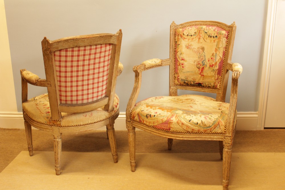 Pair of 19th-century French Louis XVI style open armchairs with off-white painted frames and pictorial tapestry upholstery. View IV