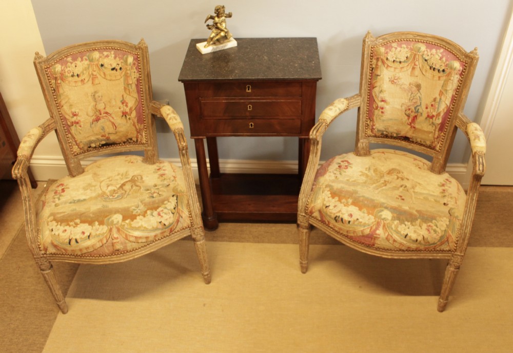 Pair of 19th-century French Louis XVI style open armchairs with off-white painted frames and pictorial tapestry upholstery. View IX