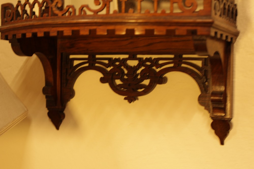 A 19th-century carved rosewood wall mirror featuring an integrated shelf with fretwork gallery, turned side columns, finials, and a bevelled mirror glass plate. View III