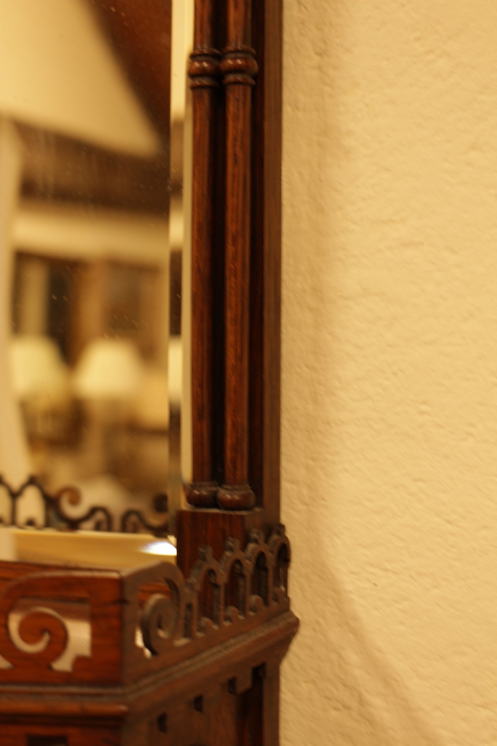 A 19th-century carved rosewood wall mirror featuring an integrated shelf with fretwork gallery, turned side columns, finials, and a bevelled mirror glass plate. View VI
