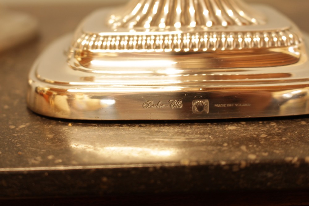 A pair of silver-plated candlesticks featuring turned fluted stems and gadrooned square bases. View VI