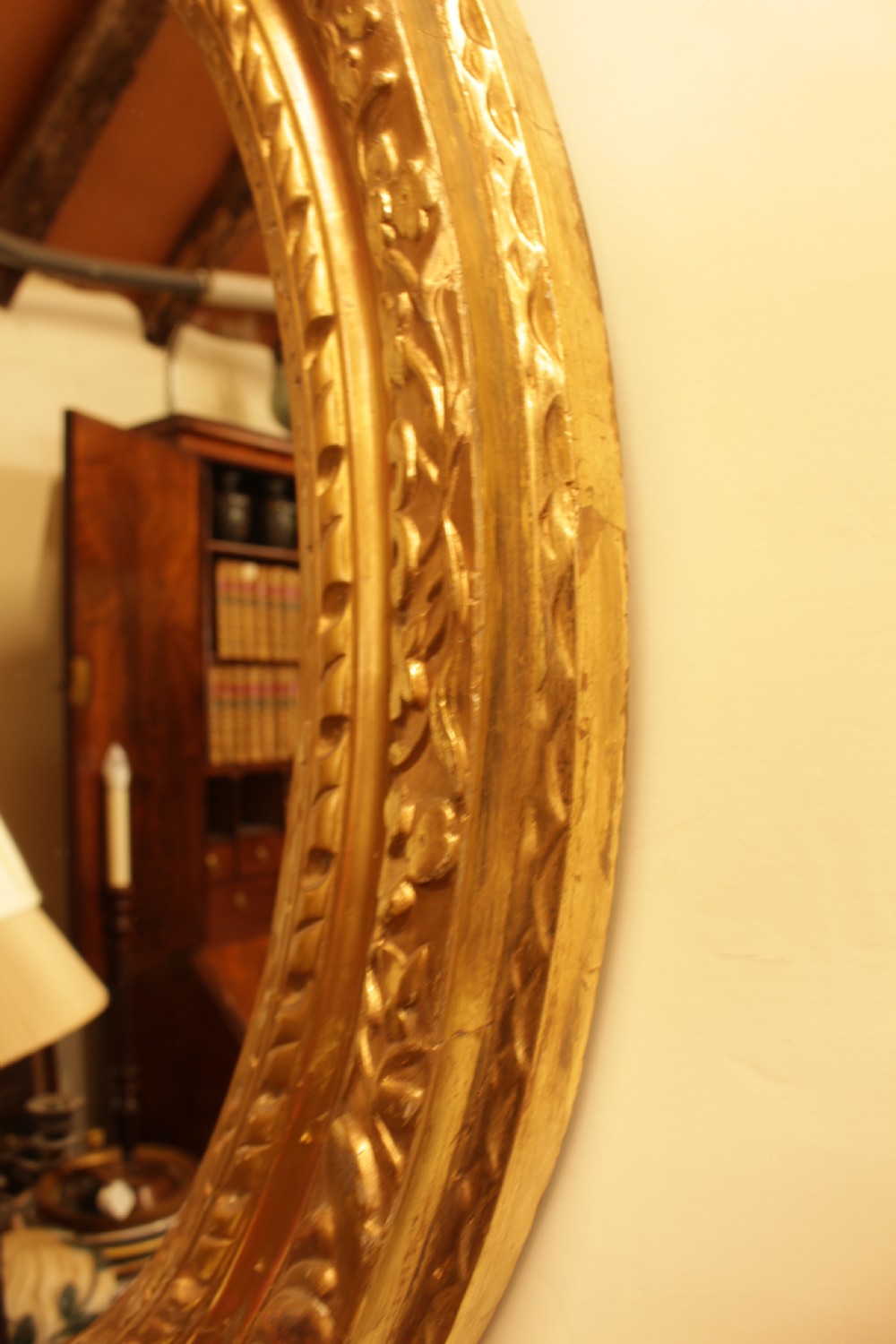 A large 18th-century Georgian oval wall mirror featuring a hand-carved giltwood frame decorated with acanthus leaf motifs. View II