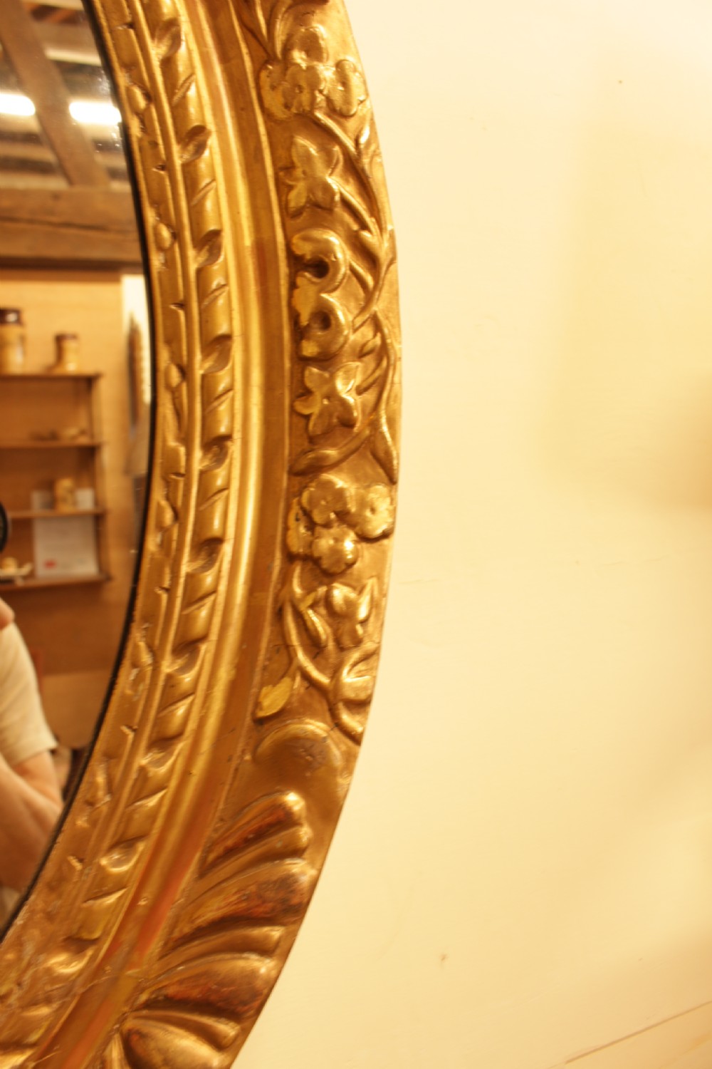 A large 18th-century Georgian oval wall mirror featuring a hand-carved giltwood frame decorated with acanthus leaf motifs. View III