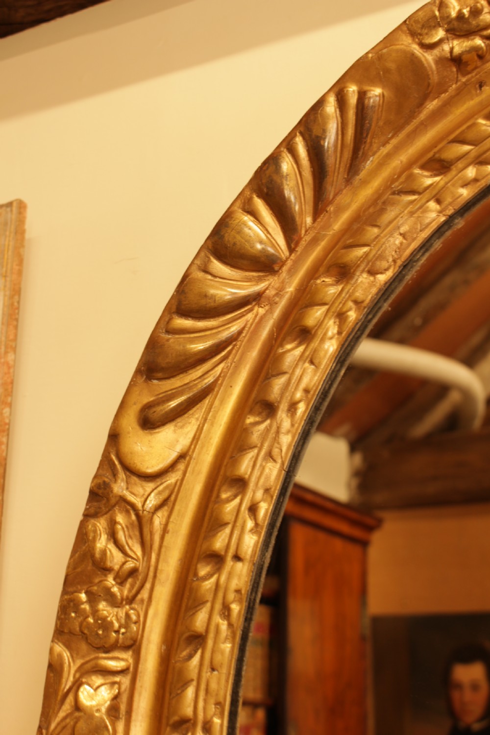 A large 18th-century Georgian oval wall mirror featuring a hand-carved giltwood frame decorated with acanthus leaf motifs. View IV