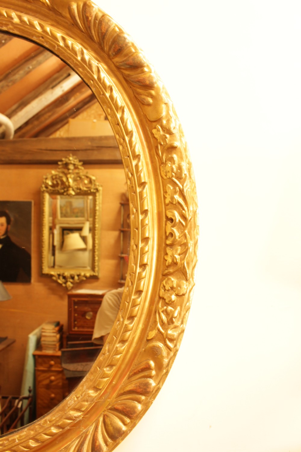 A large 18th-century Georgian oval wall mirror featuring a hand-carved giltwood frame decorated with acanthus leaf motifs. View IX