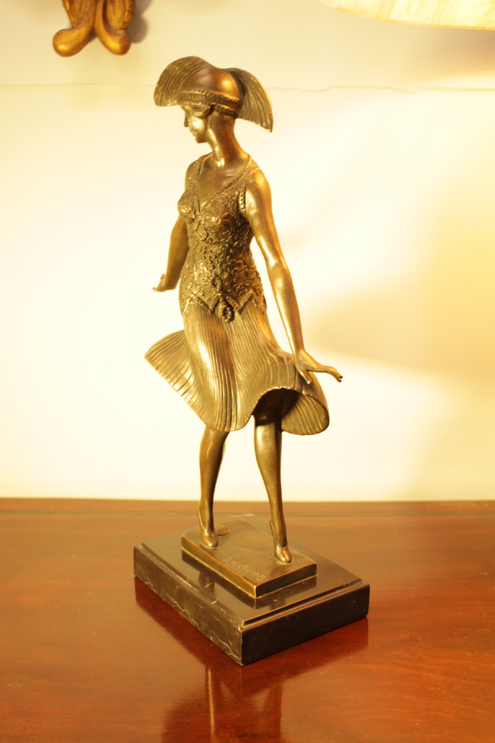 An Art Deco bronze sculpture depicting a stylized female dancer in a pleated dress and cloche headpiece mounted on a marble base. View VI