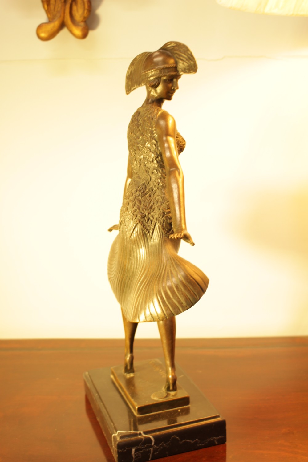 An Art Deco bronze sculpture depicting a stylized female dancer in a pleated dress and cloche headpiece mounted on a marble base. View VII