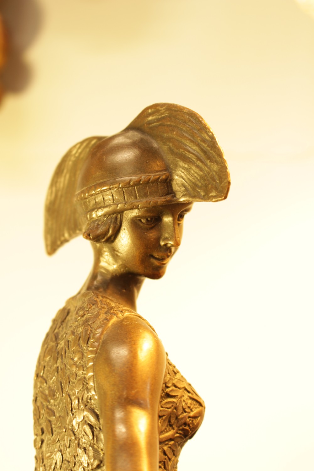An Art Deco bronze sculpture depicting a stylized female dancer in a pleated dress and cloche headpiece mounted on a marble base. View IX
