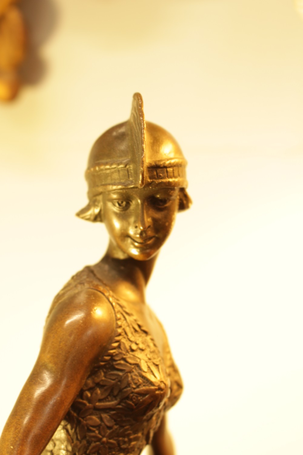 An Art Deco bronze sculpture depicting a stylized female dancer in a pleated dress and cloche headpiece mounted on a marble base. View X