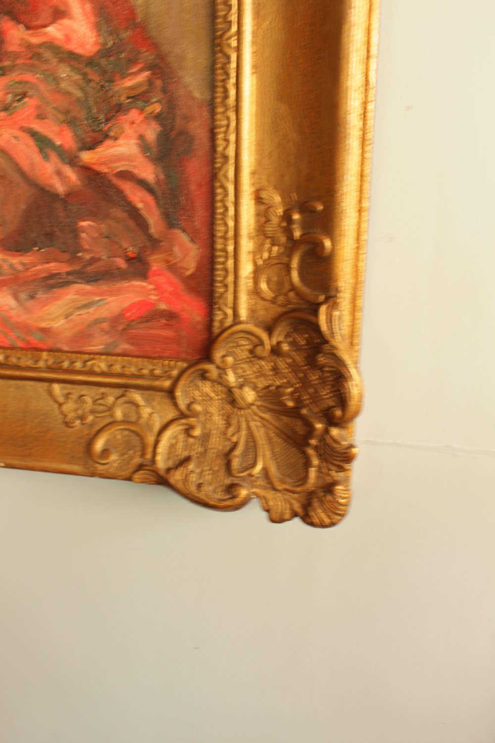 An oil painting depicting a seated woman wearing a coral shawl and a necklace, set within an ornate carved gilt frame. View V