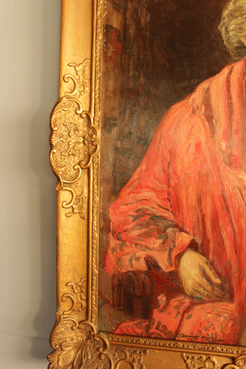 An oil painting depicting a seated woman wearing a coral shawl and a necklace, set within an ornate carved gilt frame. View VI