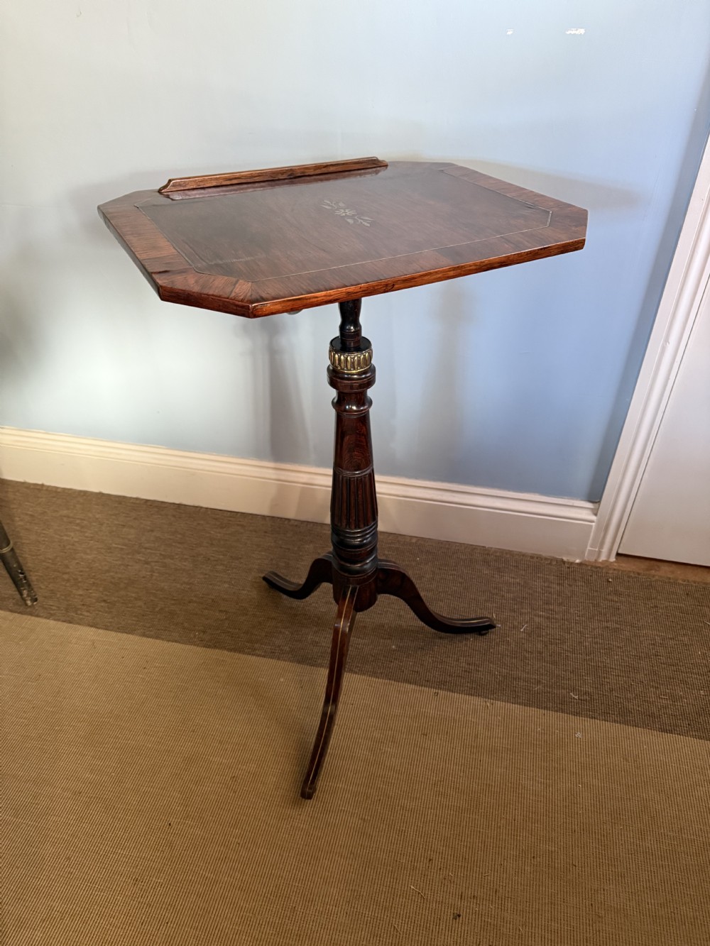 A nineteenth-century dark rosewood adjustable music stand on a turned pedestal stem and tripod base with central brass inlay on the rectangular slant top. View IX