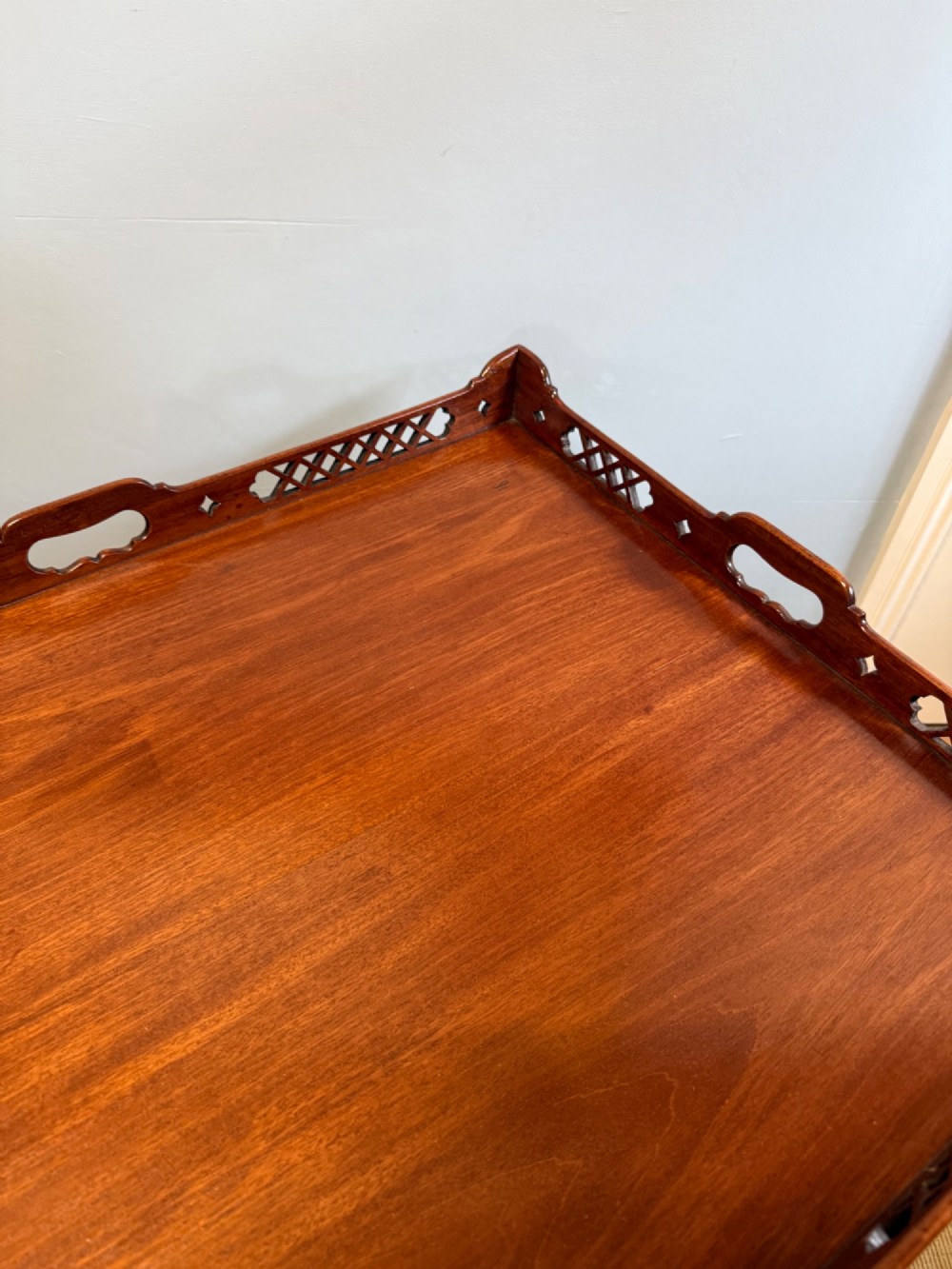 A late nineteenth-century mahogany tray top table featuring a pierced fretwork gallery, integrated cut-out side handles, and four square tapered legs. View II