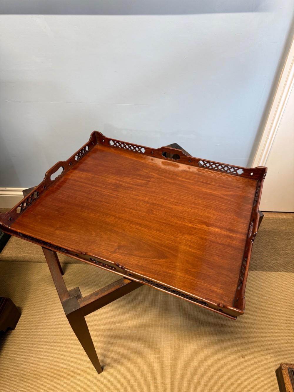 A late nineteenth-century mahogany tray top table featuring a pierced fretwork gallery, integrated cut-out side handles, and four square tapered legs. View III