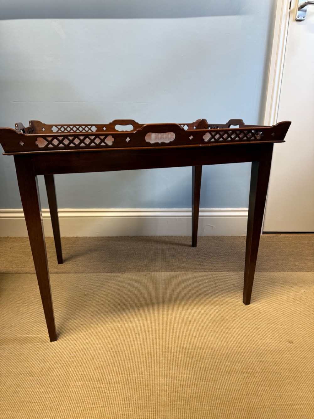 A late nineteenth-century mahogany tray top table featuring a pierced fretwork gallery, integrated cut-out side handles, and four square tapered legs. View V