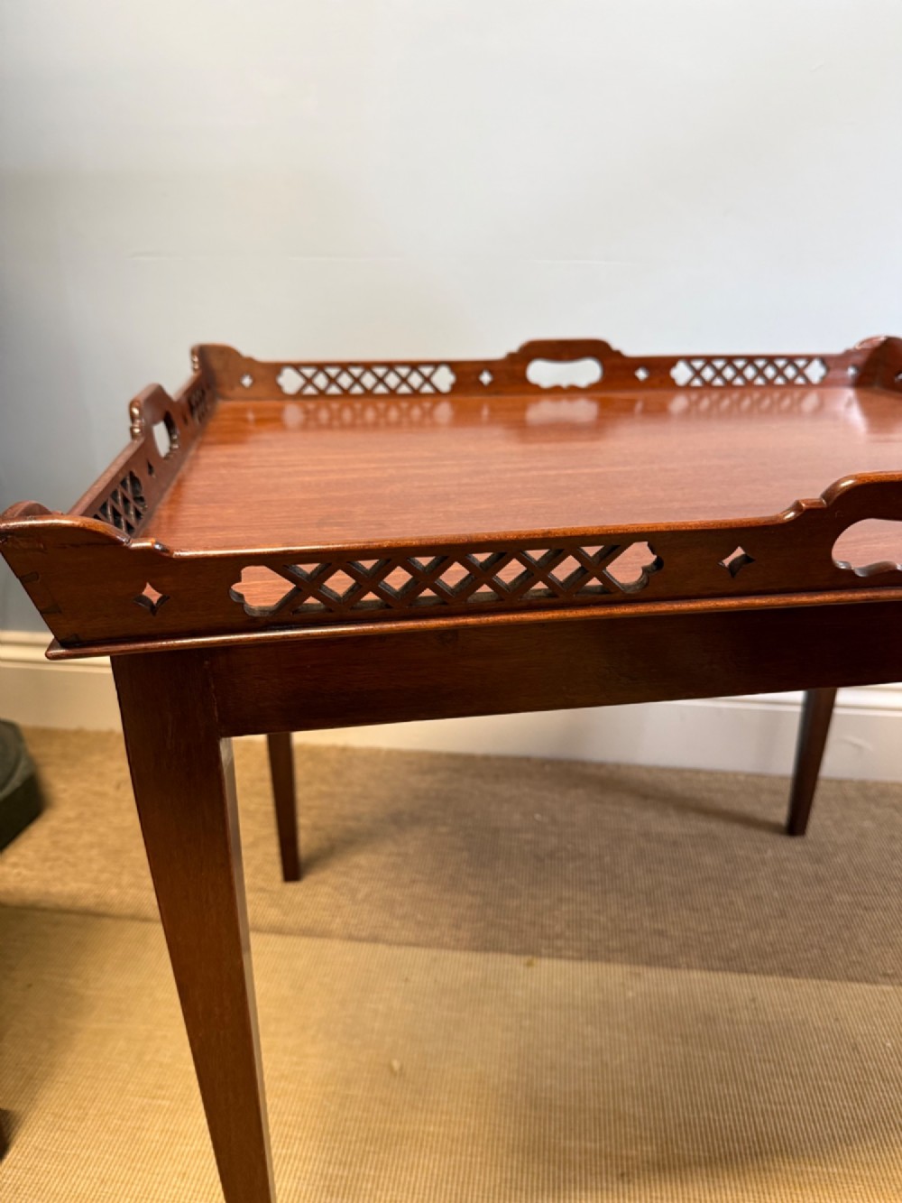 A late nineteenth-century mahogany tray top table featuring a pierced fretwork gallery, integrated cut-out side handles, and four square tapered legs. View VI