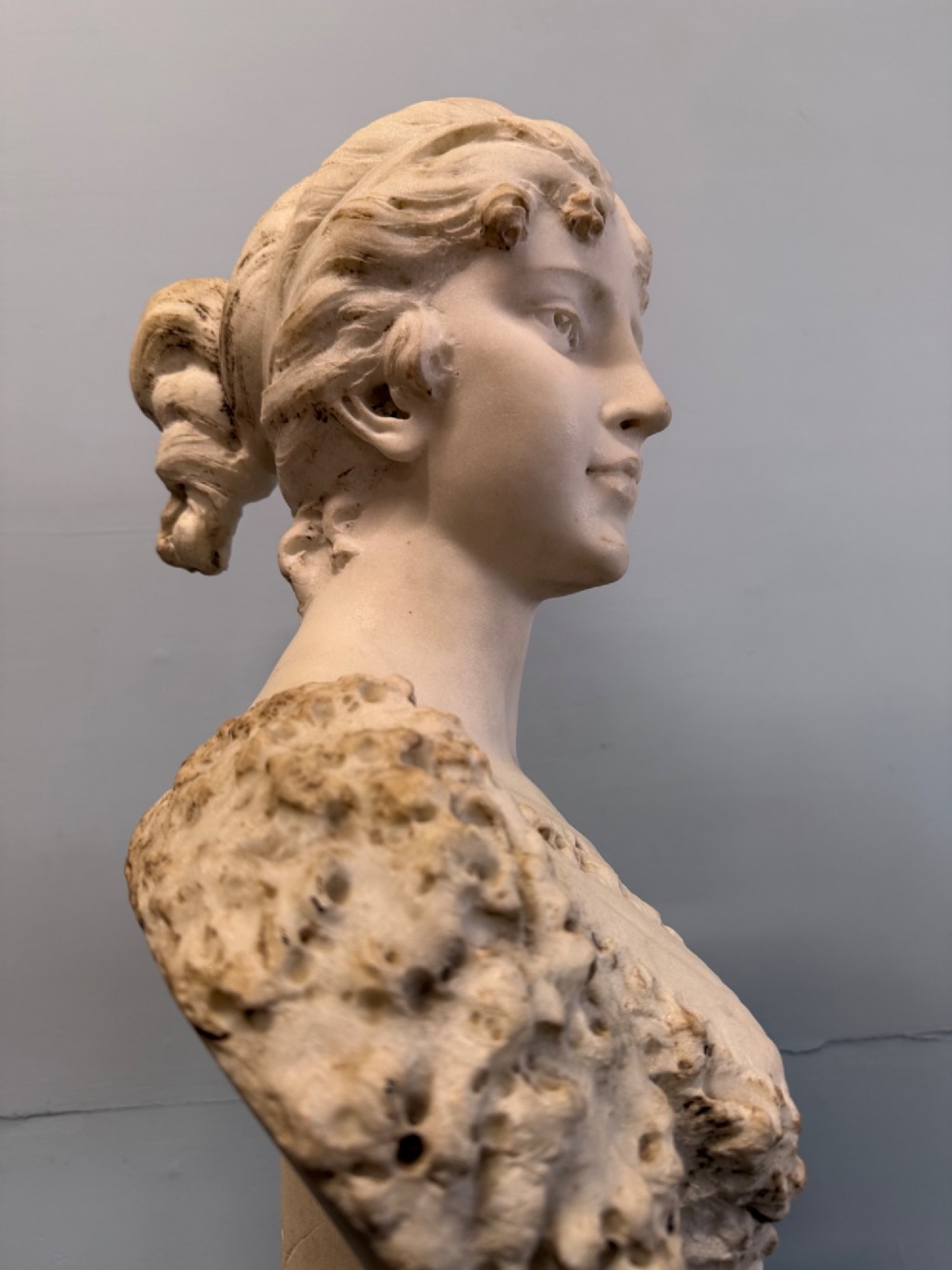 Carved white marble bust depicting Diana the Huntress with a quiver over her shoulder resting on a round moulded base. View III