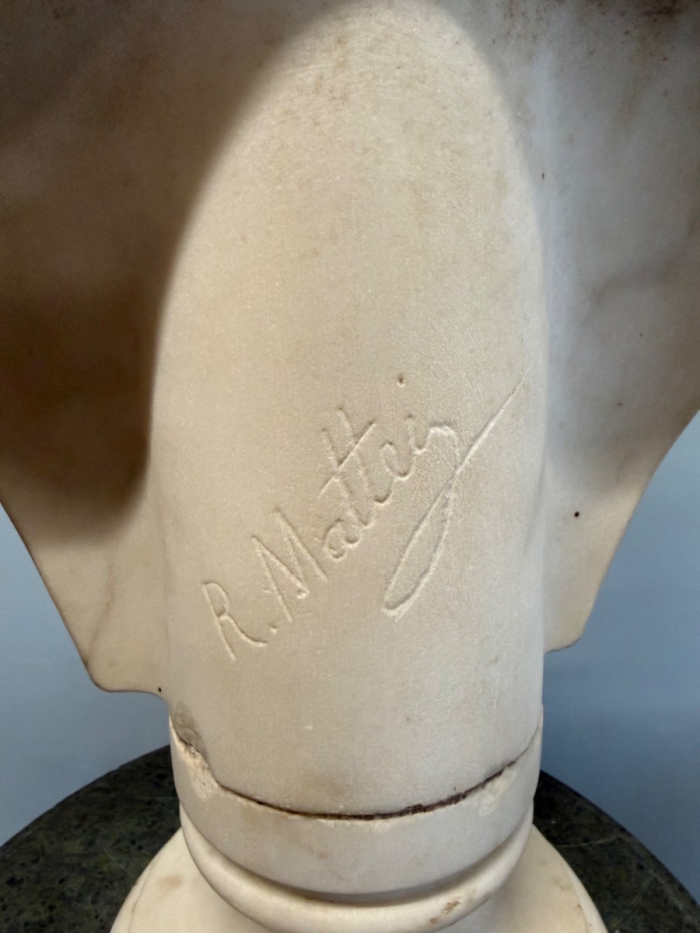 Carved white marble bust depicting Diana the Huntress with a quiver over her shoulder resting on a round moulded base. View IV